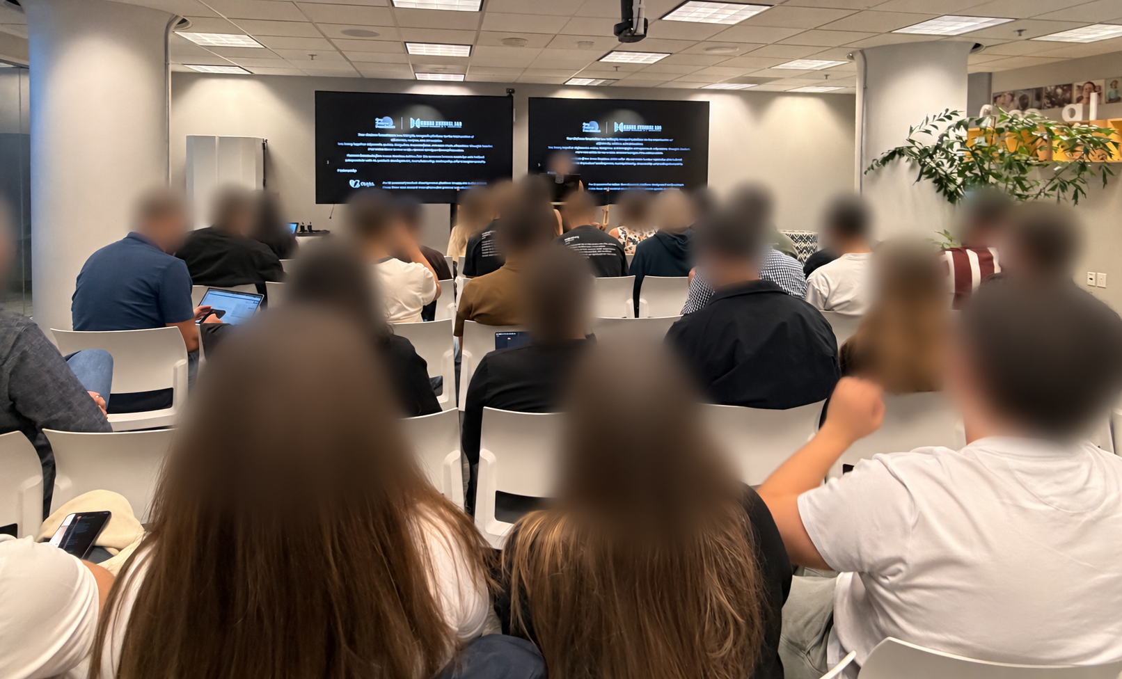 An in-person presentation during the Physical AI Hackathon, with every visible head strongly blurred for privacy